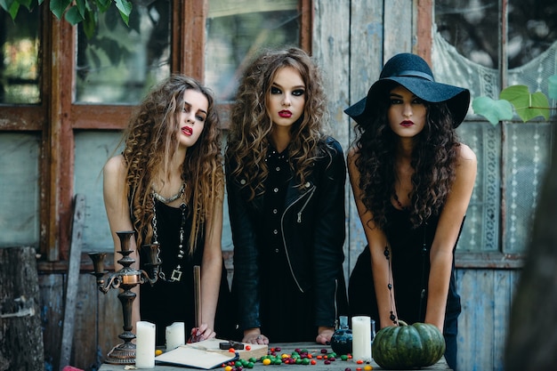 Drie heksen aan tafel aan de vooravond van Halloween