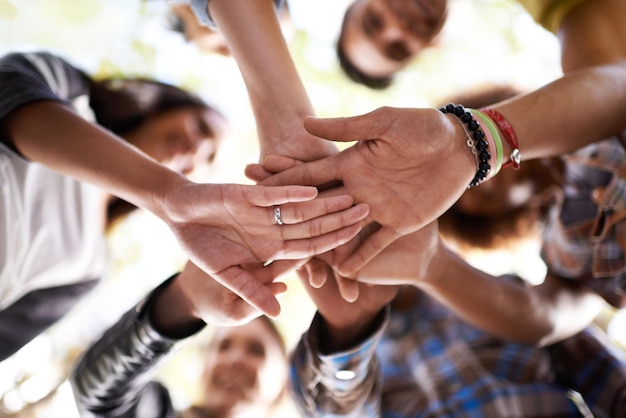 Drie hoera voor de zomer Een groep vrienden die in een kluitje staan met hun handen opgestapeld