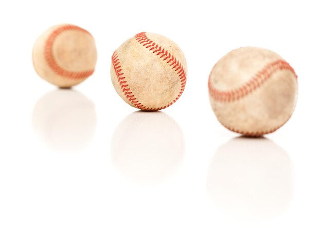Drie honkballen geïsoleerd op reflecterend wit