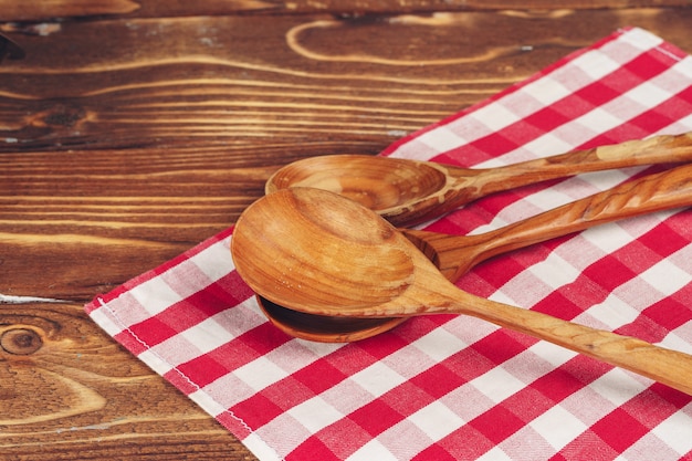 Drie houten lepels op een geruit servet op keukentafel