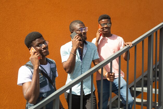 drie jonge afrikaanse mannen bellen mobiel