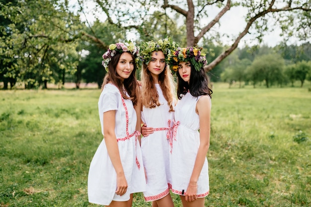 Drie jonge meisjes in witte etnische jurken outdoor portret.
