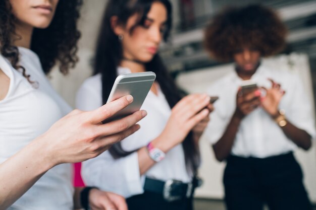 Drie jonge ondernemers interactie en het delen van gegevens met smartphone