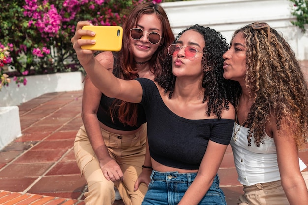 Drie jonge vrienden die buitenshuis een selfie maken