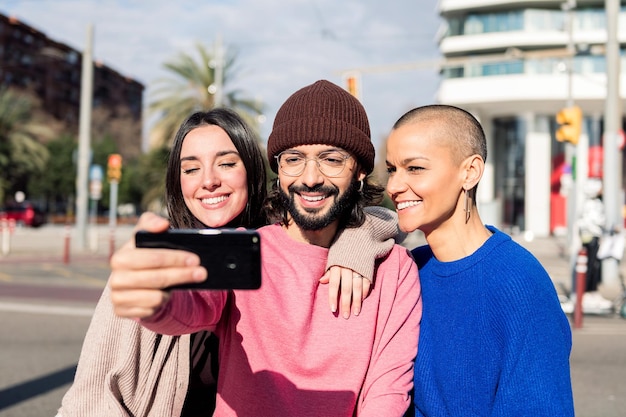 Drie jonge vrienden die een selfie maken in de stad