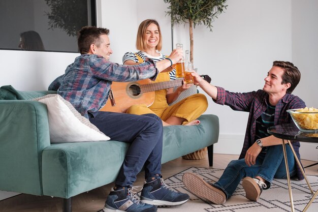 Drie jonge vrienden drinken met bier op een feestje thuis Concept levensstijl vriendschap samen