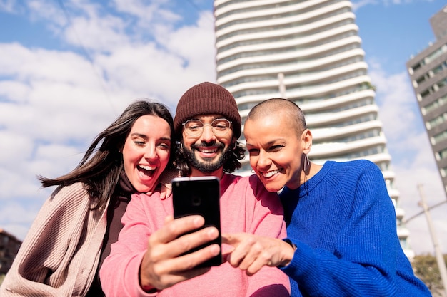 Drie jonge vrienden genieten samen met een telefoon