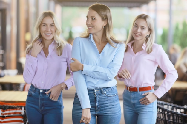 drie jonge vrouwelijke vrienden in shirts met lange mouwen, kledingreclame, effen overhemden zakelijke dame kantoorstijl