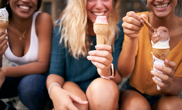 Foto drie jonge vrouwen eten ijsjes van dichtbij.