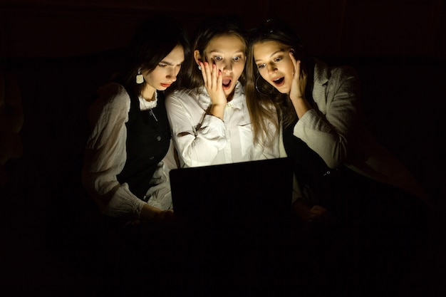 drie jonge vrouwen op de bank bij de laptop