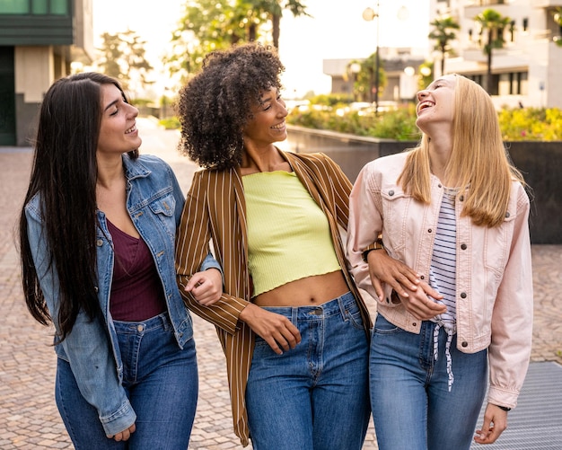 Drie jonge vrouwen van generatie z wandelen in de stad, zomerse vibes en geluk