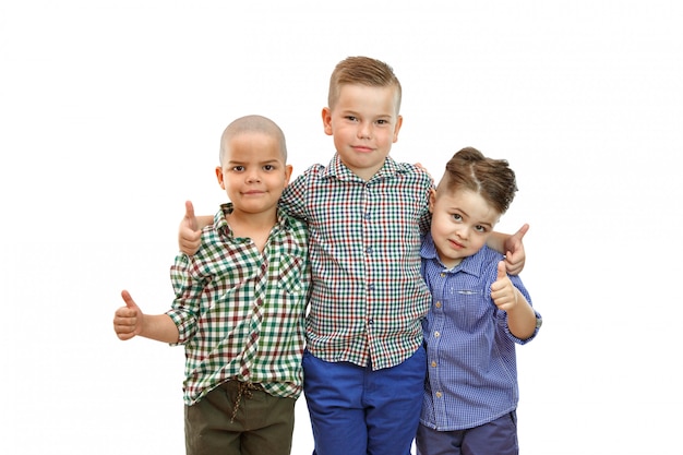 Foto drie jongens staan samen en houden hun duimen omhoog