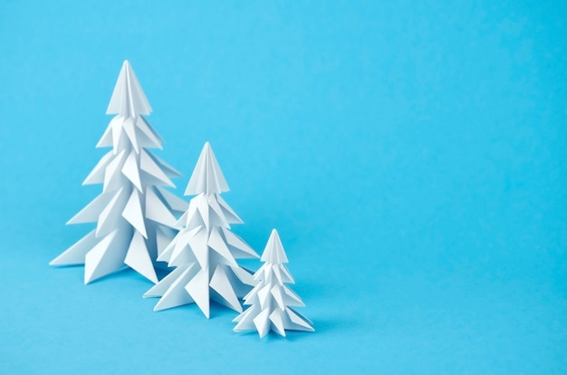 Drie kerstbomen van de Witboekorigami op blauw