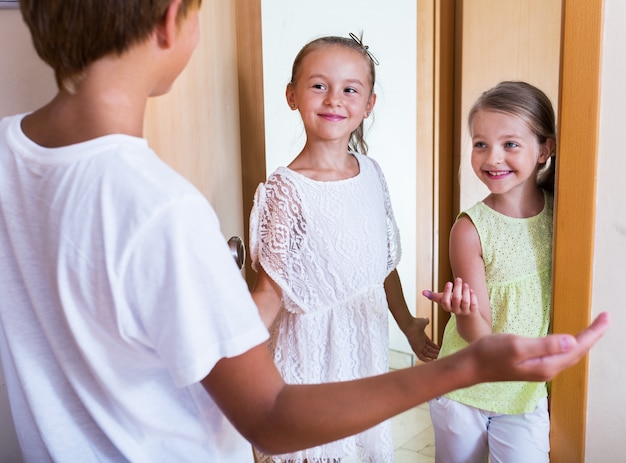 Drie kinderen bij de ingang van het huis