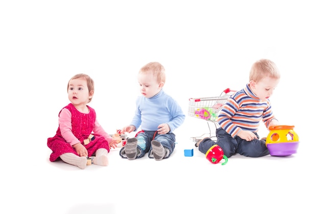 Drie kinderen spelen met speelgoed geïsoleerd op wit