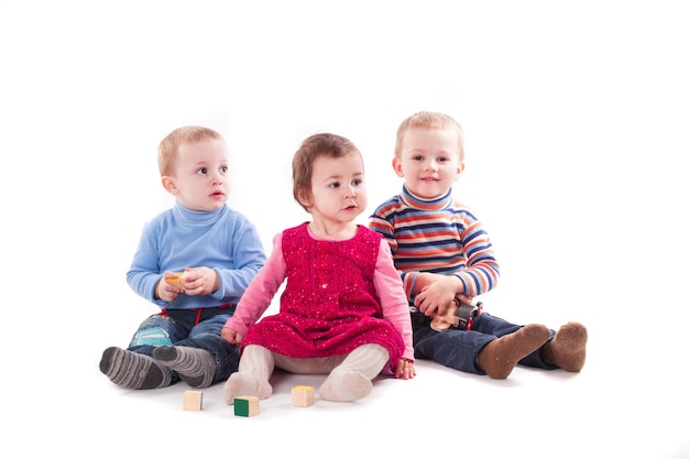 Drie kinderen spelen met speelgoed geïsoleerd op wit