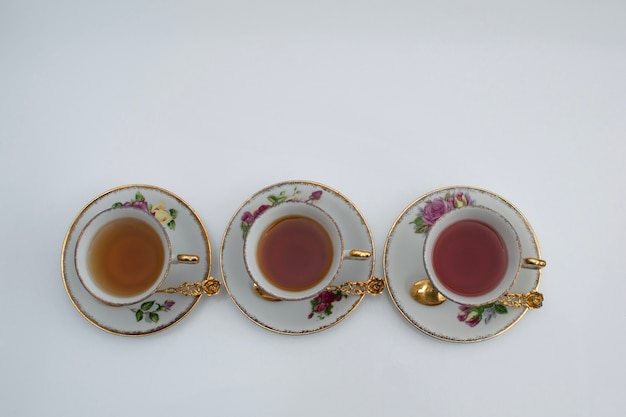 Drie klassieke stijl van witte en gouden theekoppen met verschillend soort thee