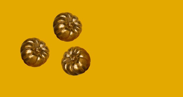 Drie kleine gouden pompoenen op gele achtergrond Levitatie herfst halloween concept Plaats voor tekst