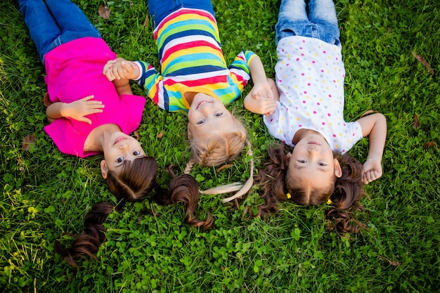 Foto drie kleine meisjes van aziatische, indiase en europese etnische rassen liggen op de gajon