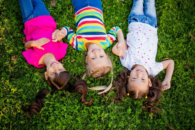 Foto drie kleine meisjes van aziatische, indiase en europese etnische rassen liggen op de gajon