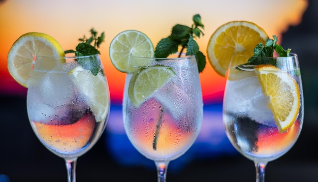 Drie kleurrijke gin tonic cocktails in glazen bij toog in pup