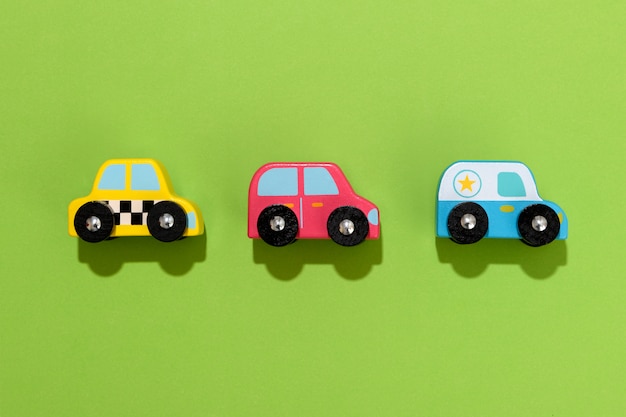 Drie kleurrijke houten speelgoed auto's op groene achtergrond
