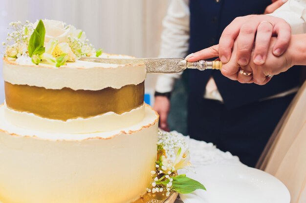 Drie lagen witte bruidstaart versierd met bloemen van mastic op een witte houten tafel afbeelding voor een menu of een snoepcatalogus met kopieerruimte