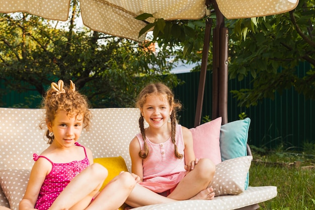 Drie lieve zusjes op zachte tuinschommel