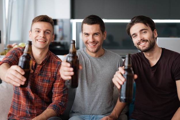 Drie mannen drinken bier. Jongens gelukkig samen.