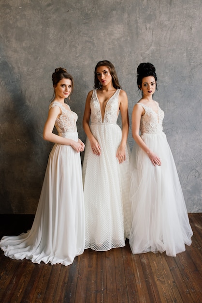 Foto drie meisjes in de studio in elegante witte jurken. huwelijksfoto, mooie bruiden in de studio.