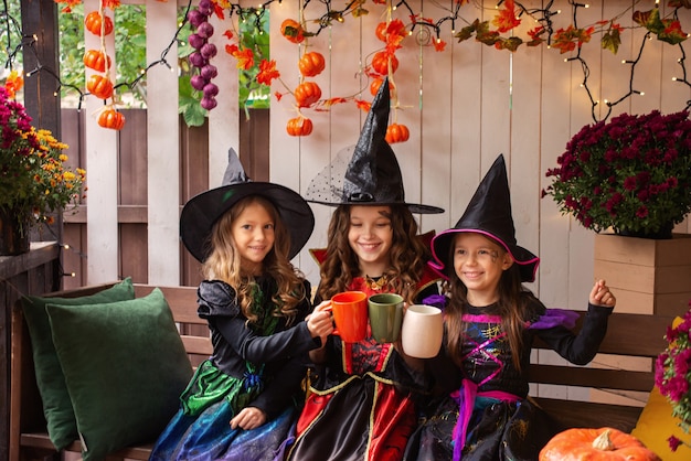 drie meisjeszussen in heksenkostuums veel plezier met het vieren van Halloween