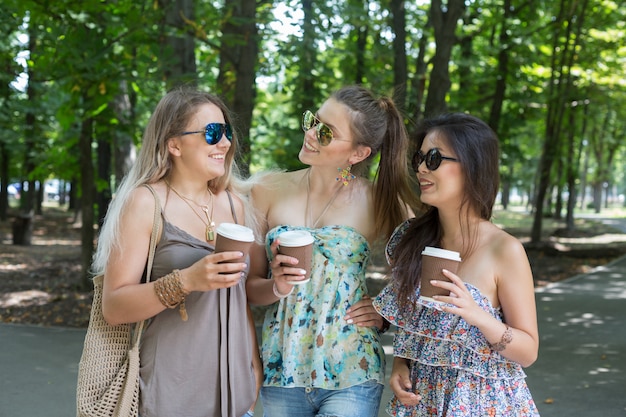 Drie mooie jonge vrouwen die in het park lopen