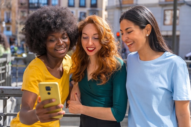 Drie multiraciale jonge vrouwen die een selfie maken in het stadsvriendschapsconcept feminisme