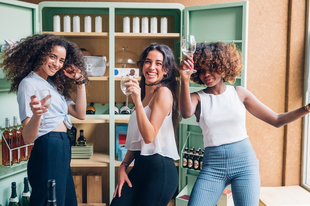 Drie multiraciale vrouwen plezier hebben en dansen in moderne pub