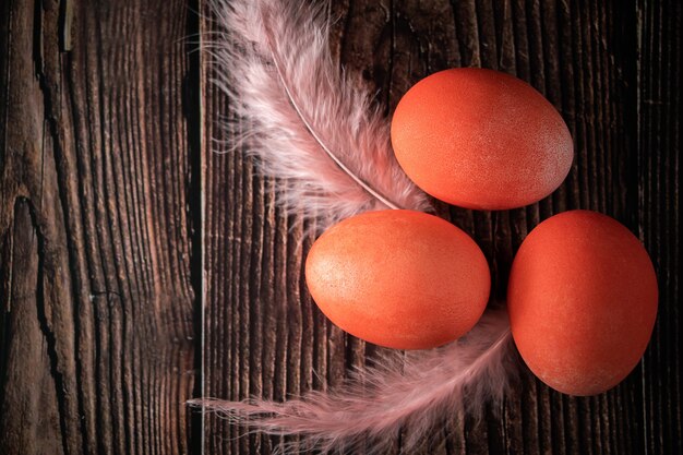 Drie oranje paaseieren en veren