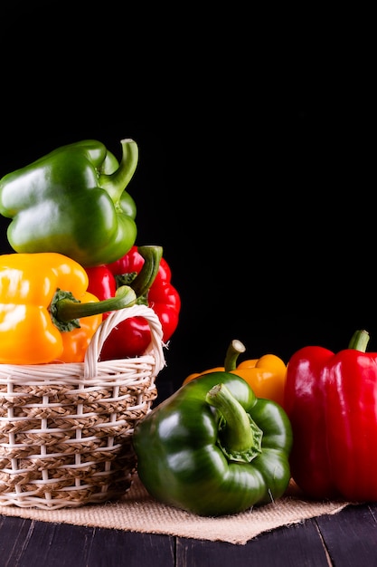 Drie paprika's op een houten tafel, plantaardige salade koken