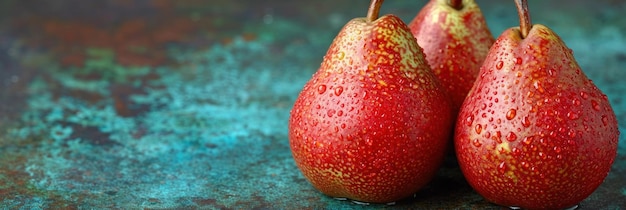 Drie peren zitten op een tafel met waterdruppels.