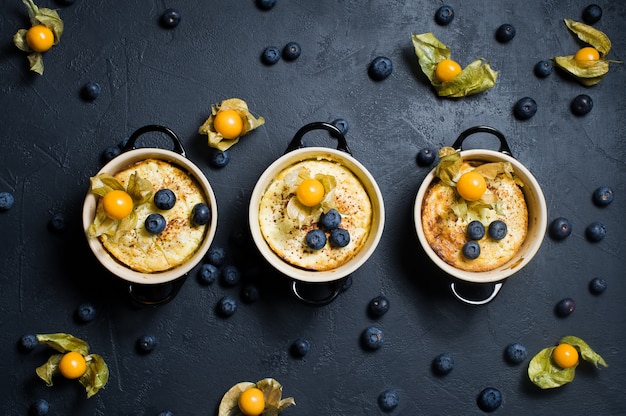 Drie porties klassieke Engelse rijstpudding. Bosbessen en physalis.