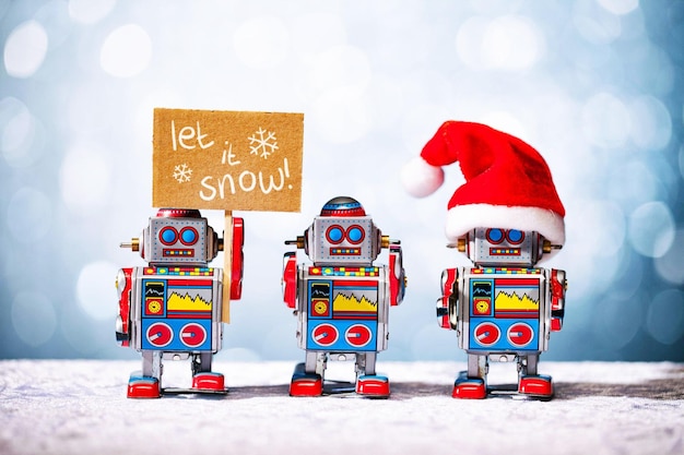Drie retro robots poseren voor Kerstmis. Laat het sneeuwen, kerstman.