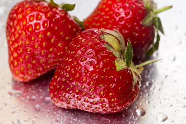 Drie rijpe aardbeien op wit