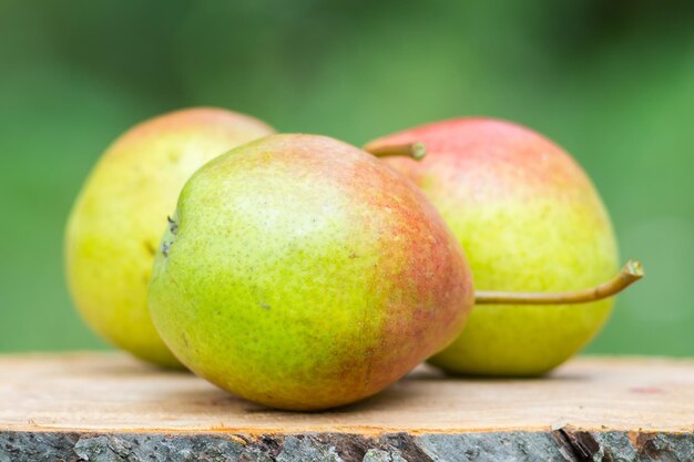 Drie rijpe biologische peren op een houten bord wazig achtergrond selectieve focus