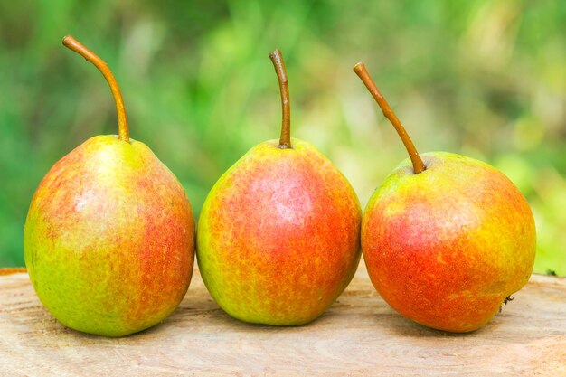 Drie rijpe biologische peren op een houten bord wazig achtergrond selectieve focus