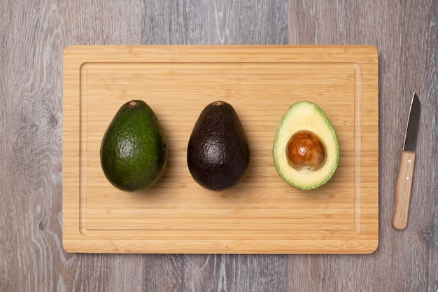 Drie rijpe haas avocado's op snijplank