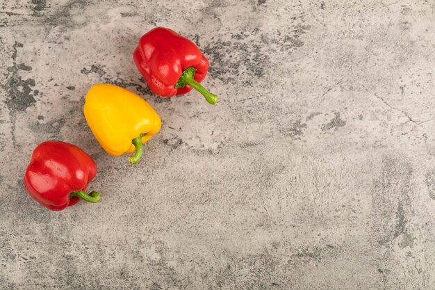 Drie rijpe paprika's op stenen oppervlak