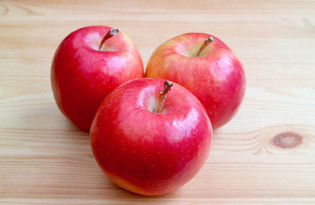 Drie rode appels op houten tafel achtergrond