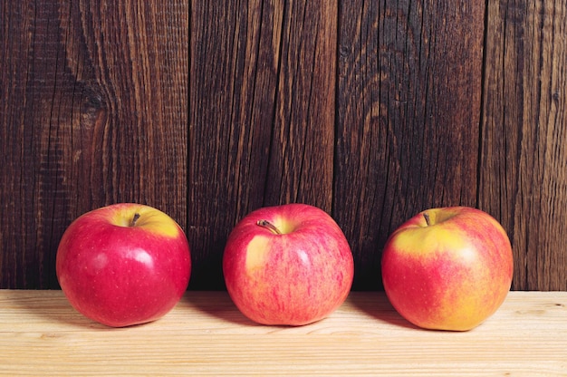 Drie rode appels op tafel bedekt geel tafelkleed