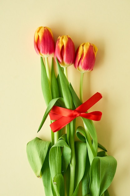 Drie rode en gele tulpen op licht