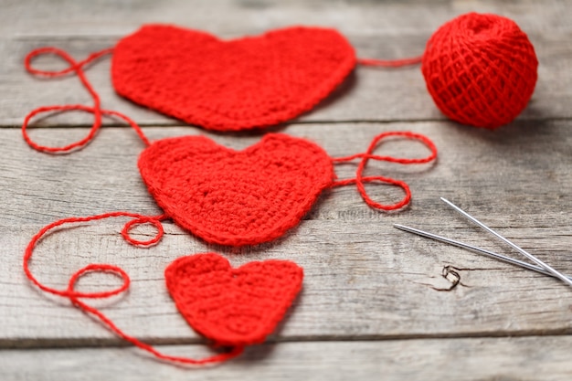 Drie rode gebreide harten, die liefde en familie symboliseren. Familierelatie, obligaties.