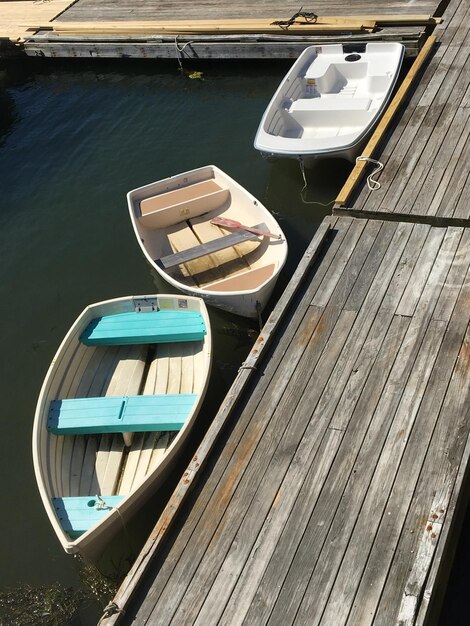 Foto drie roeibooten langs een pier