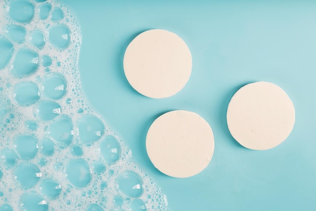 Foto drie ronde stukjes witte zeep met schuim